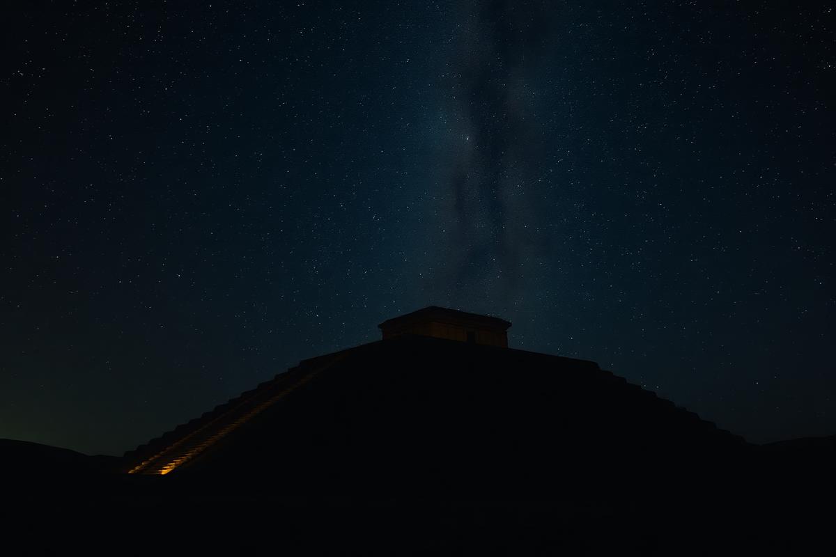 Silhouette of a Mesopotamian ziggurat beneath a dense starfield